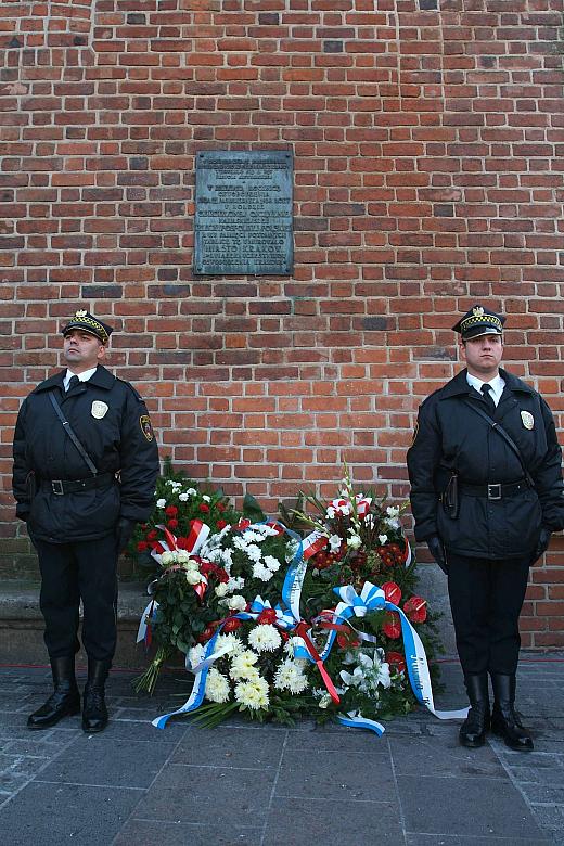 Honorowa warta przy pamiątkowej tablicy.