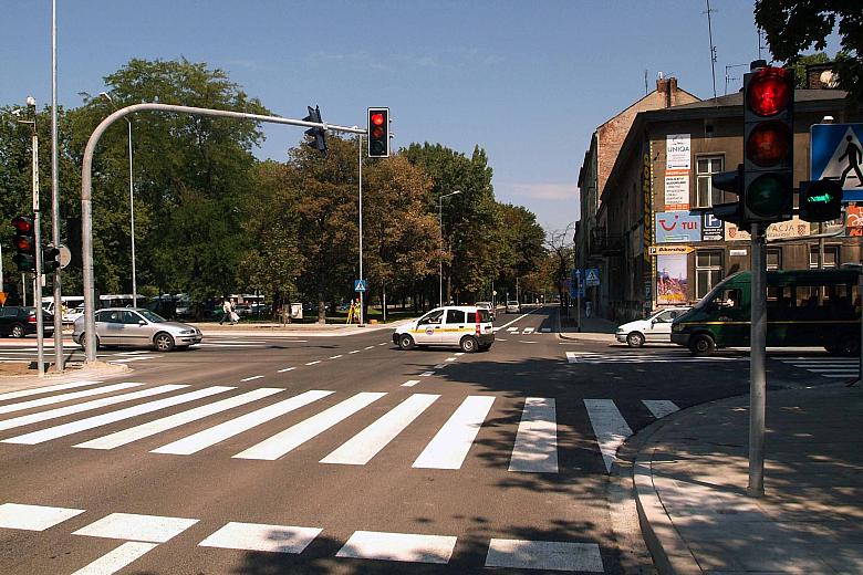 Skrzyżowanie Alej z ulicą Czarnowiejską, nowoczesne rozwiązanie komunikacyjne na pierwszym planie, a w tle Park Krakowski, w któ