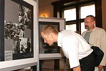 Andrzej Fischer (na pierwszym planie), jeden z komendantów marszu z zaciekawieniem ogląda fotografie.